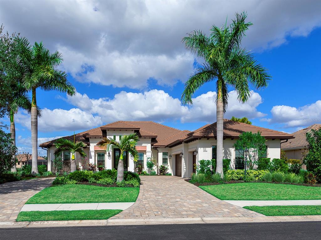 11708 Rive Isle Run Parrish, FL 34219 - Photo 64 of 65 a front view of a house with a garden and yard