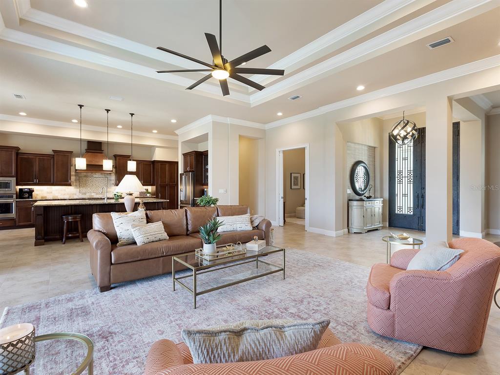 11708 Rive Isle Run Parrish, FL 34219 - Photo 10 of 65 a living room with furniture kitchen view and a chandelier