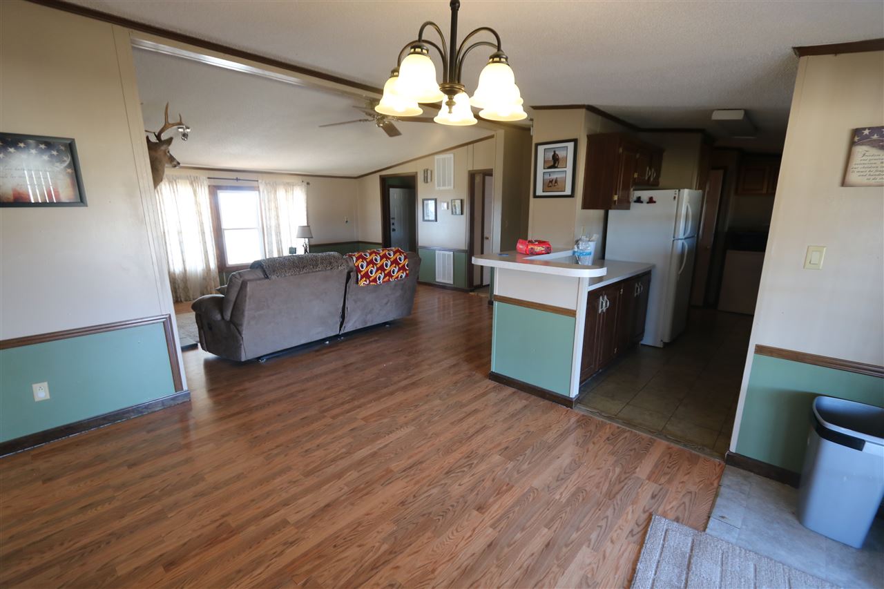 86 Middle Lane Road Grottoes, VA 24441 - Photo 33 of 50 a living room with kitchen island granite countertop wooden floor and a chandelier