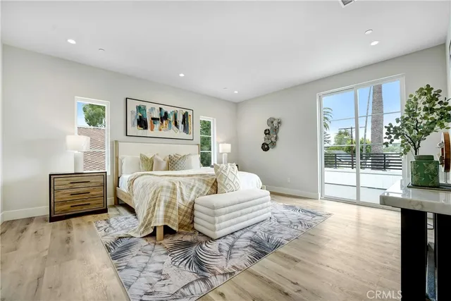 a spacious bedroom with a bed and wooden floor