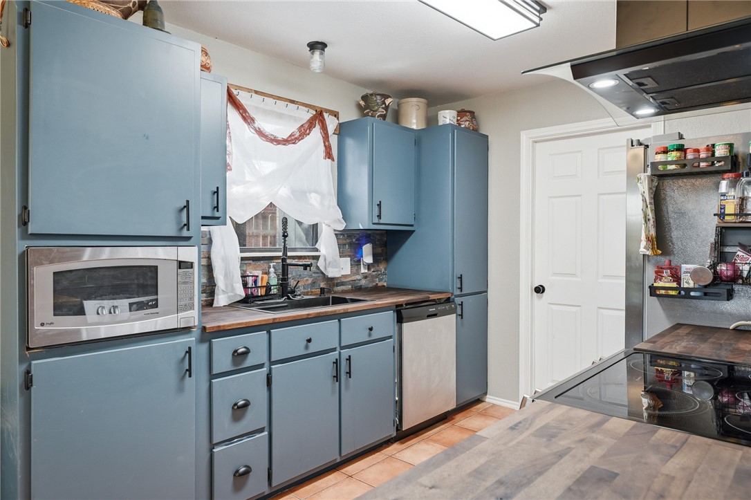 2169 Timberleaf Circle Ingleside, TX 78362 - Photo 13 of 36 a kitchen with stainless steel appliances granite countertop a stove and a wooden cabinets