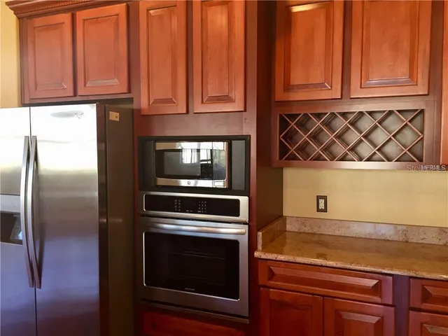 a kitchen with granite countertop wooden cabinets and a stove