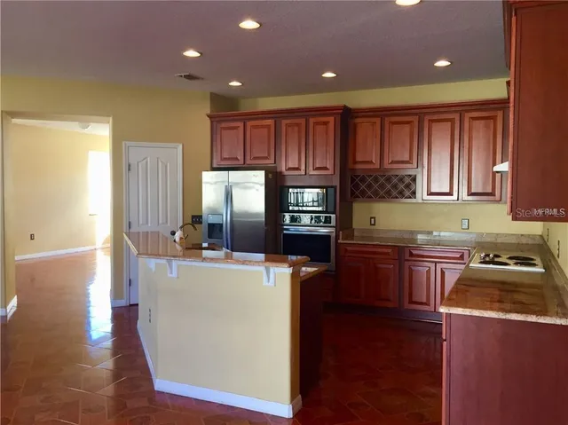 a kitchen with a refrigerator a stove top oven a sink and dishwasher with wooden floor