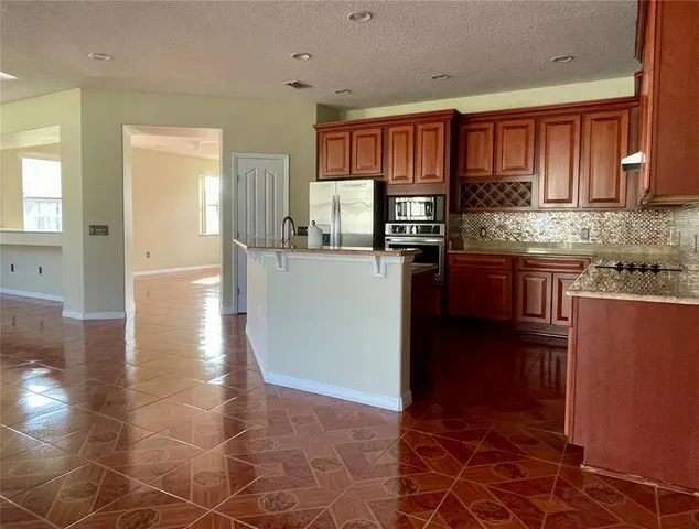 a kitchen with stainless steel appliances granite countertop a refrigerator stove and sink