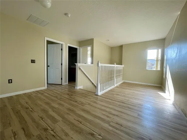 a view of a livingroom with wooden floor and window
