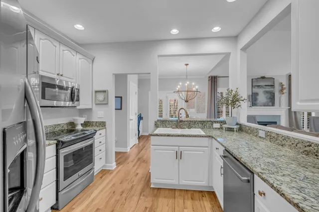 a kitchen with granite countertop a sink stove and refrigerator