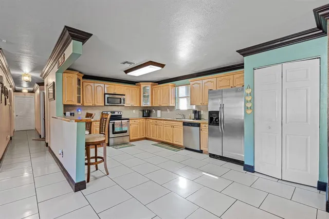 a kitchen with stainless steel appliances granite countertop a refrigerator and a sink