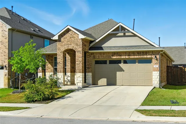 a front view of a house with a garden