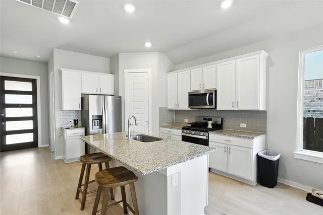 a kitchen with stainless steel appliances granite countertop a sink stove and refrigerator