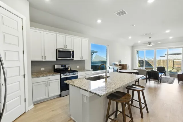 a kitchen with white cabinets and stainless steel appliances
