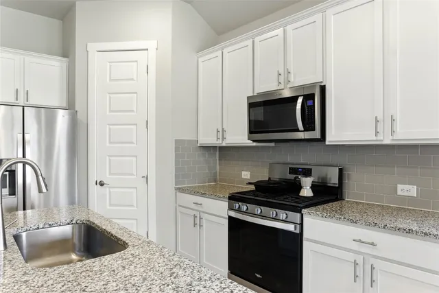a kitchen with granite countertop a sink a counter top space and living room area