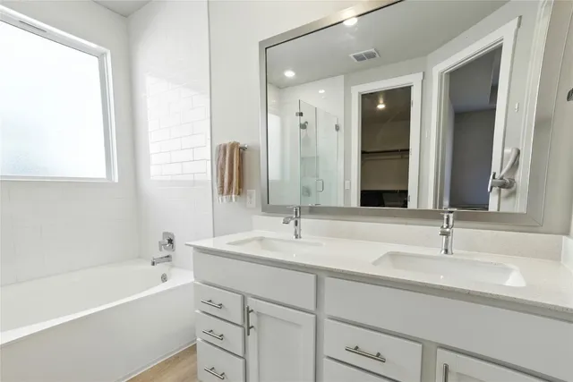 a bathroom with a tub sink and mirror