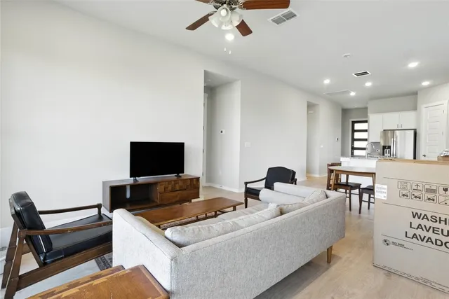 a living room with furniture a flat screen tv and a floor to ceiling window