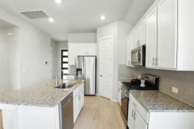 a kitchen with a table chairs refrigerator and microwave