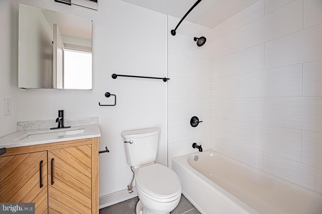 5001 Umbria Street, Unit U310 Philadelphia, PA 19128 - Photo 9 of 10 a bathroom with a granite countertop toilet a sink and a bathtub