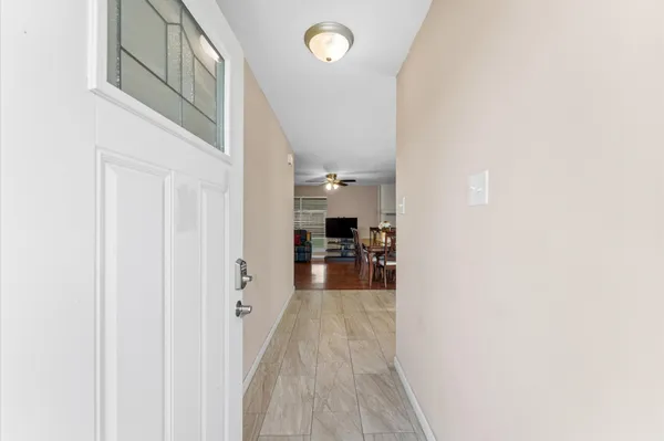 a view of a hallway with a livingroom and a hall with wooden floor