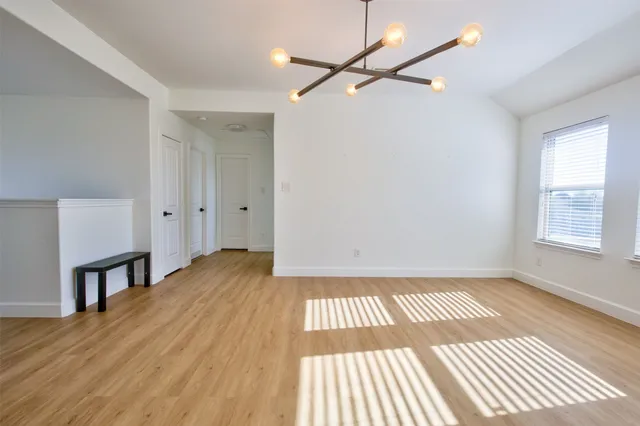 a view of a room with wooden floor a ceiling fan and window