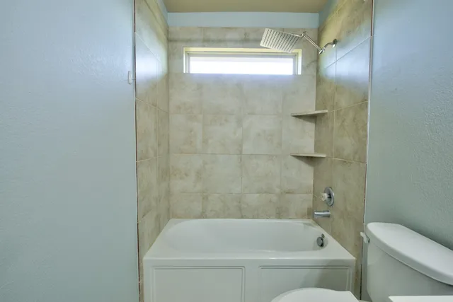 a bathroom with a bathtub and a toilet