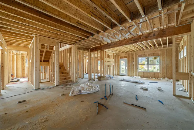 a bed sitting in a spacious bedroom next to a window