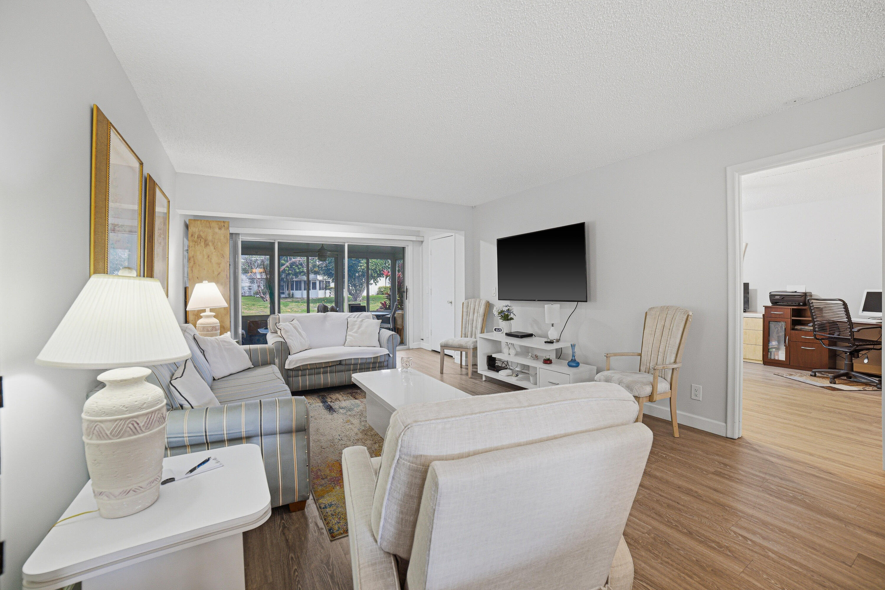 2901 Southwest 15th Street, Unit 102 Delray Beach, FL 33445 - Photo 12 of 59 a living room with furniture a flat screen tv and a large window