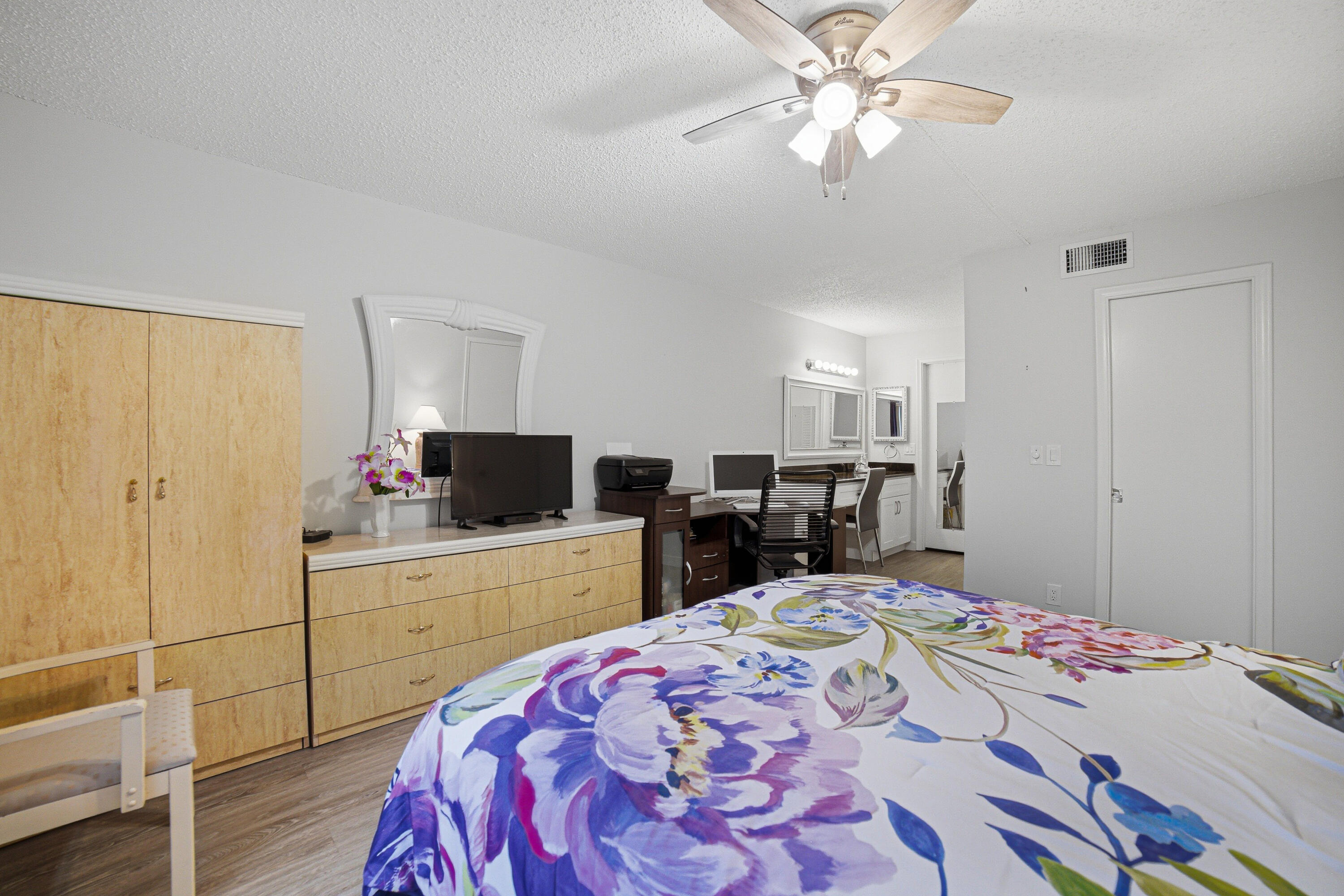 2901 Southwest 15th Street, Unit 102 Delray Beach, FL 33445 - Photo 17 of 59 a bed room with a bed and a chandelier