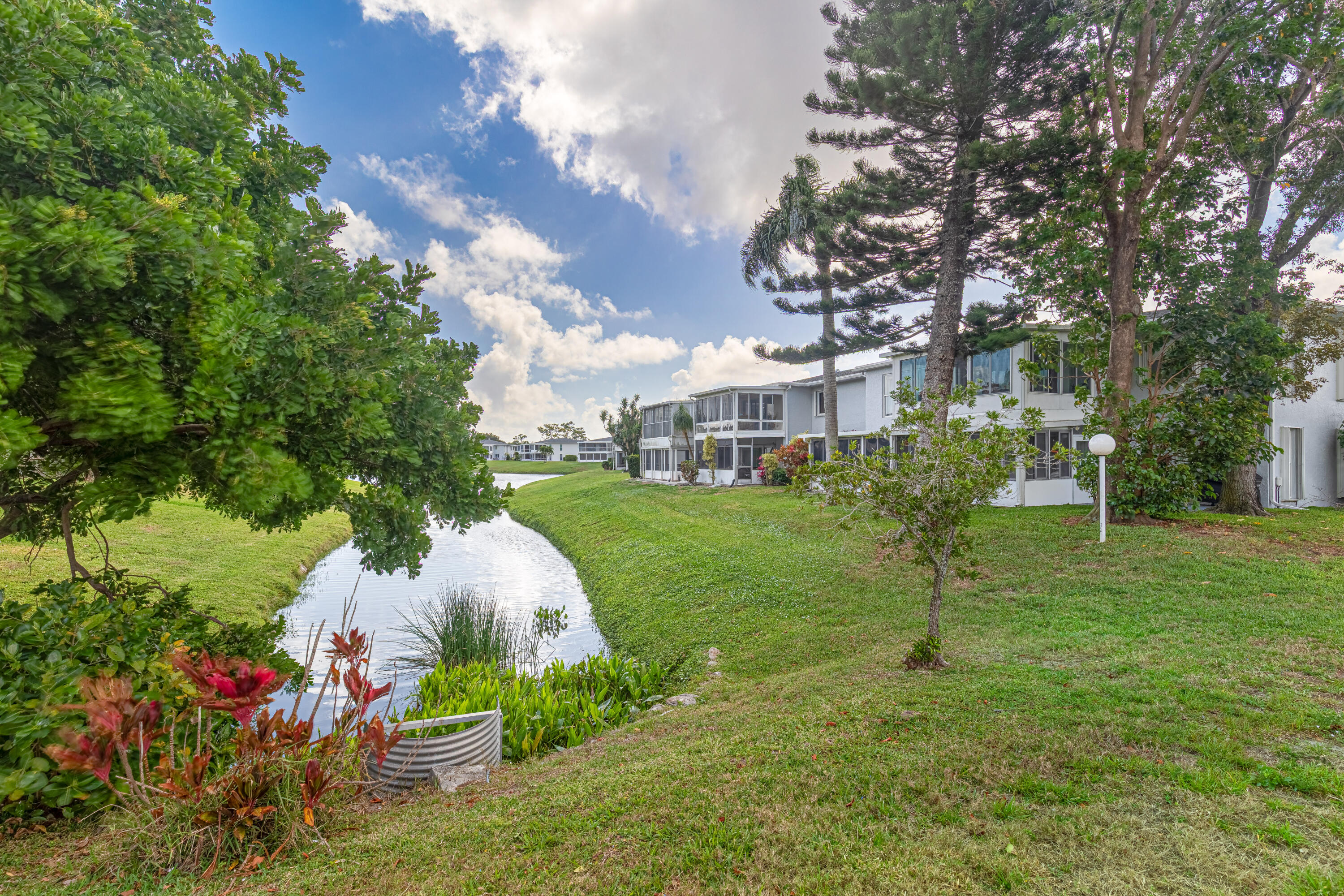 2901 Southwest 15th Street, Unit 102 Delray Beach, FL 33445 - Photo 27 of 59 a view of a garden with plants and large trees