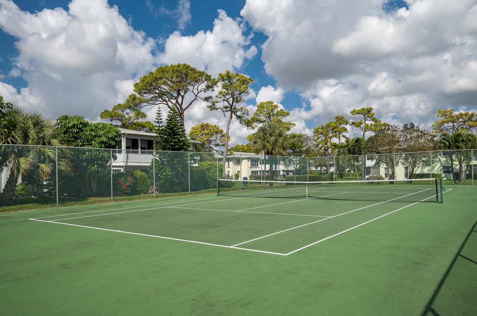 2901 Southwest 15th Street, Unit 102 Delray Beach, FL 33445 - Photo 44 of 59 a view of a tennis ground with large trees