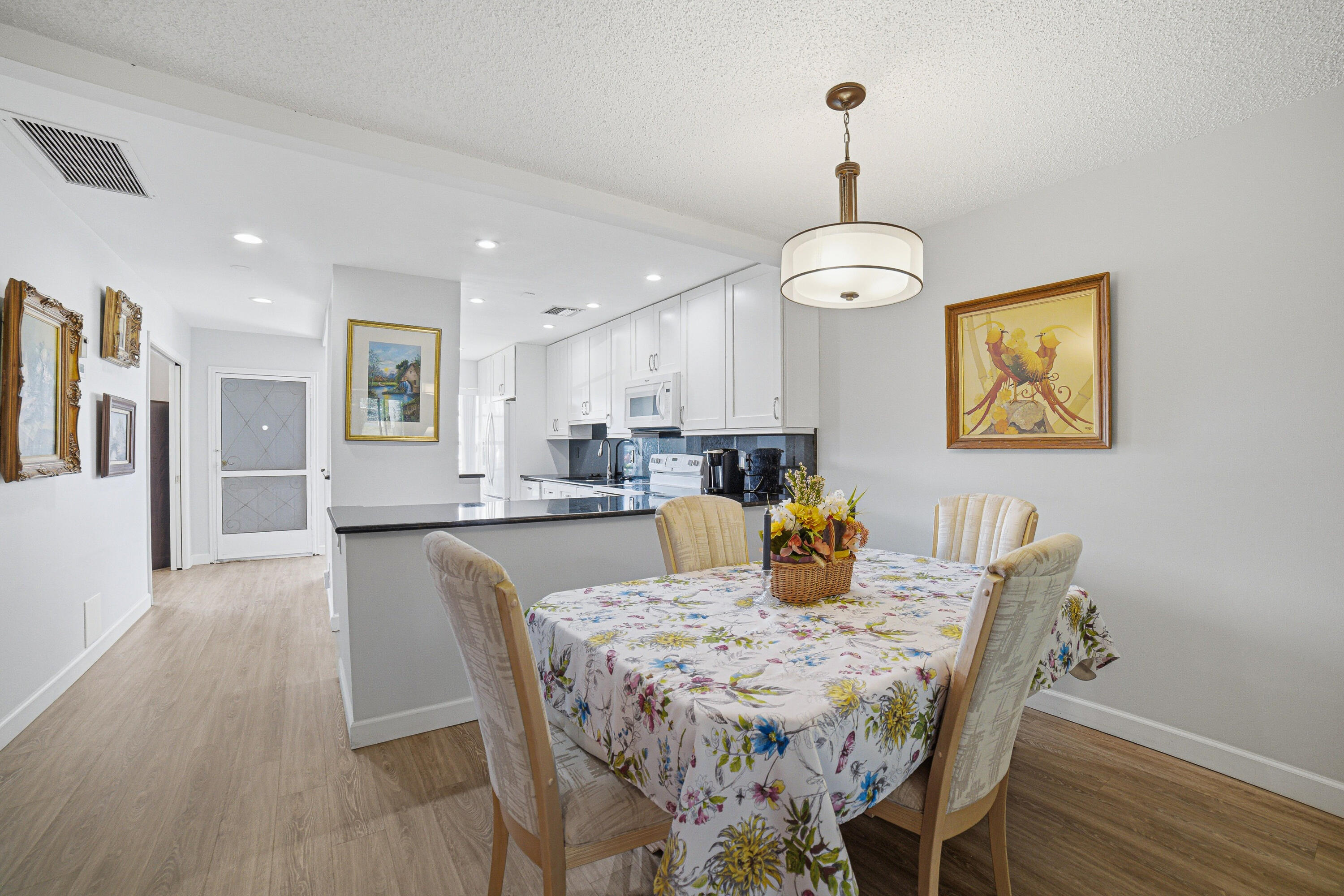 2901 Southwest 15th Street, Unit 102 Delray Beach, FL 33445 - Photo 10 of 59 a view of a dining room with furniture wooden floor and chandelier