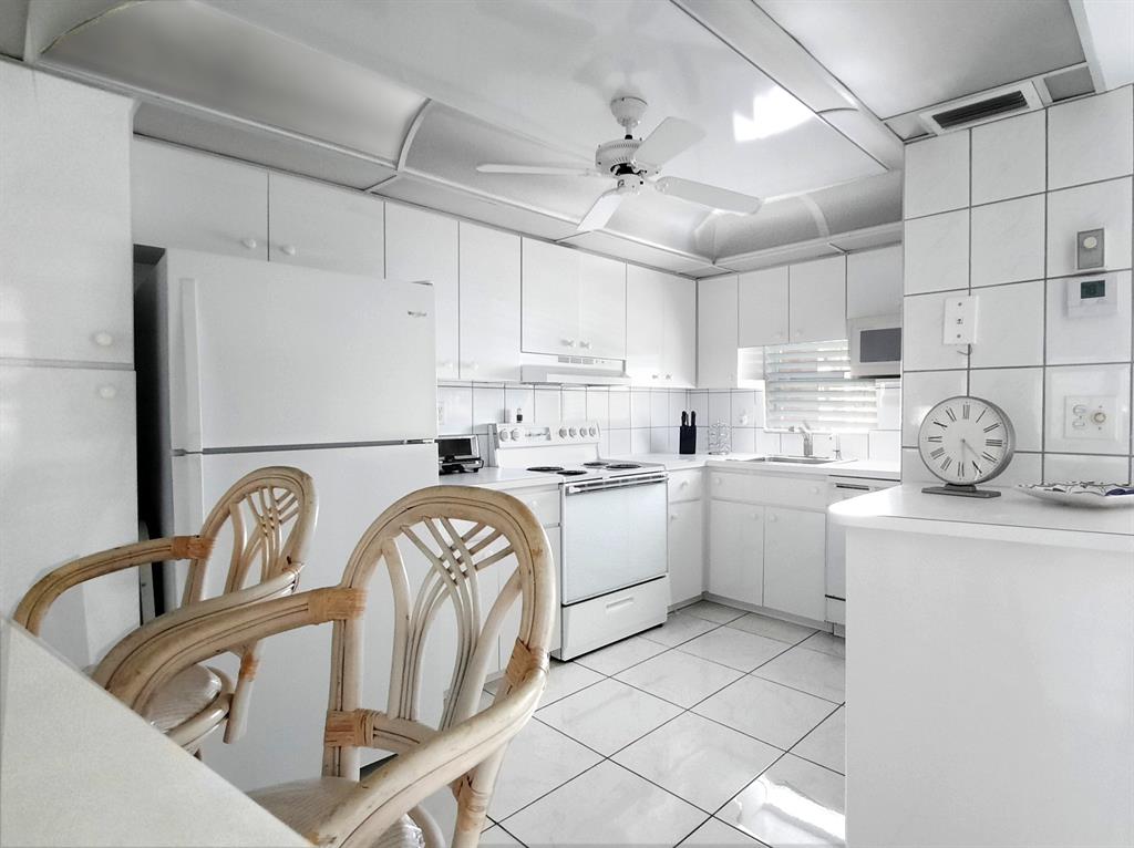 a kitchen with granite countertop a sink cabinets and appliances