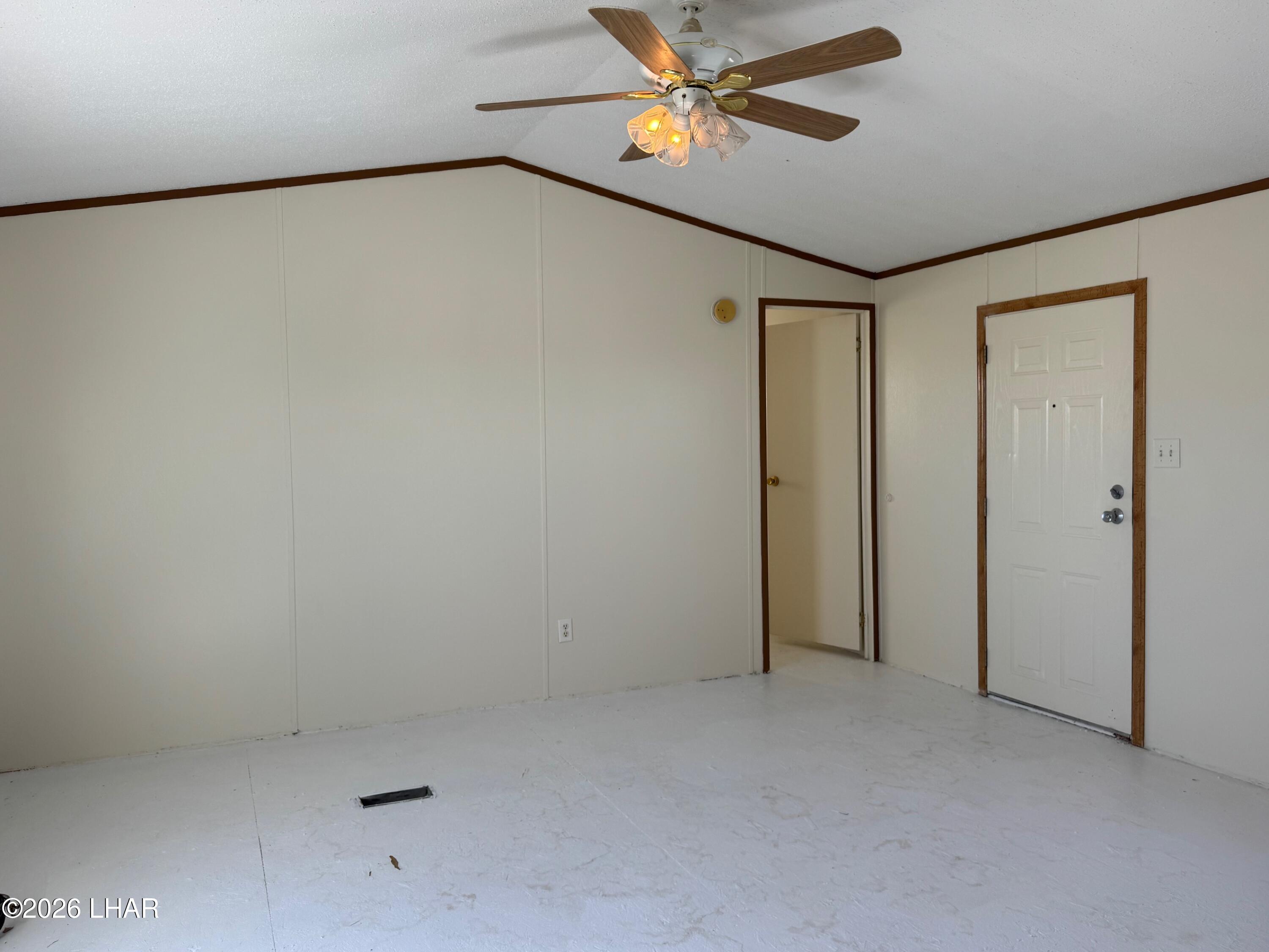 15454 Mohave Road Yucca, AZ 86438 - Photo 23 of 47 an empty room with a ceiling fan and a window