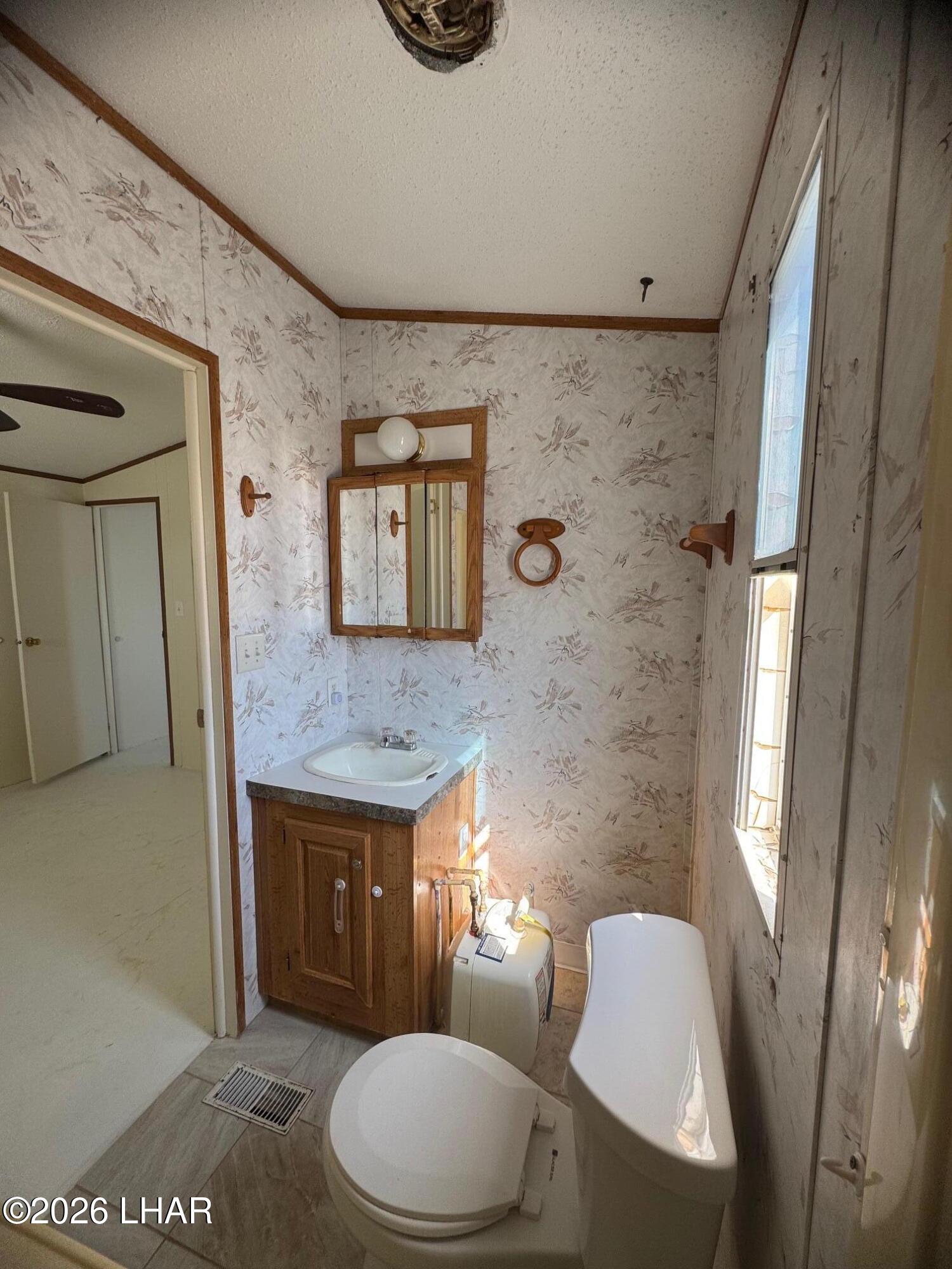 15454 Mohave Road Yucca, AZ 86438 - Photo 27 of 47 a bathroom with a toilet a sink and a mirror