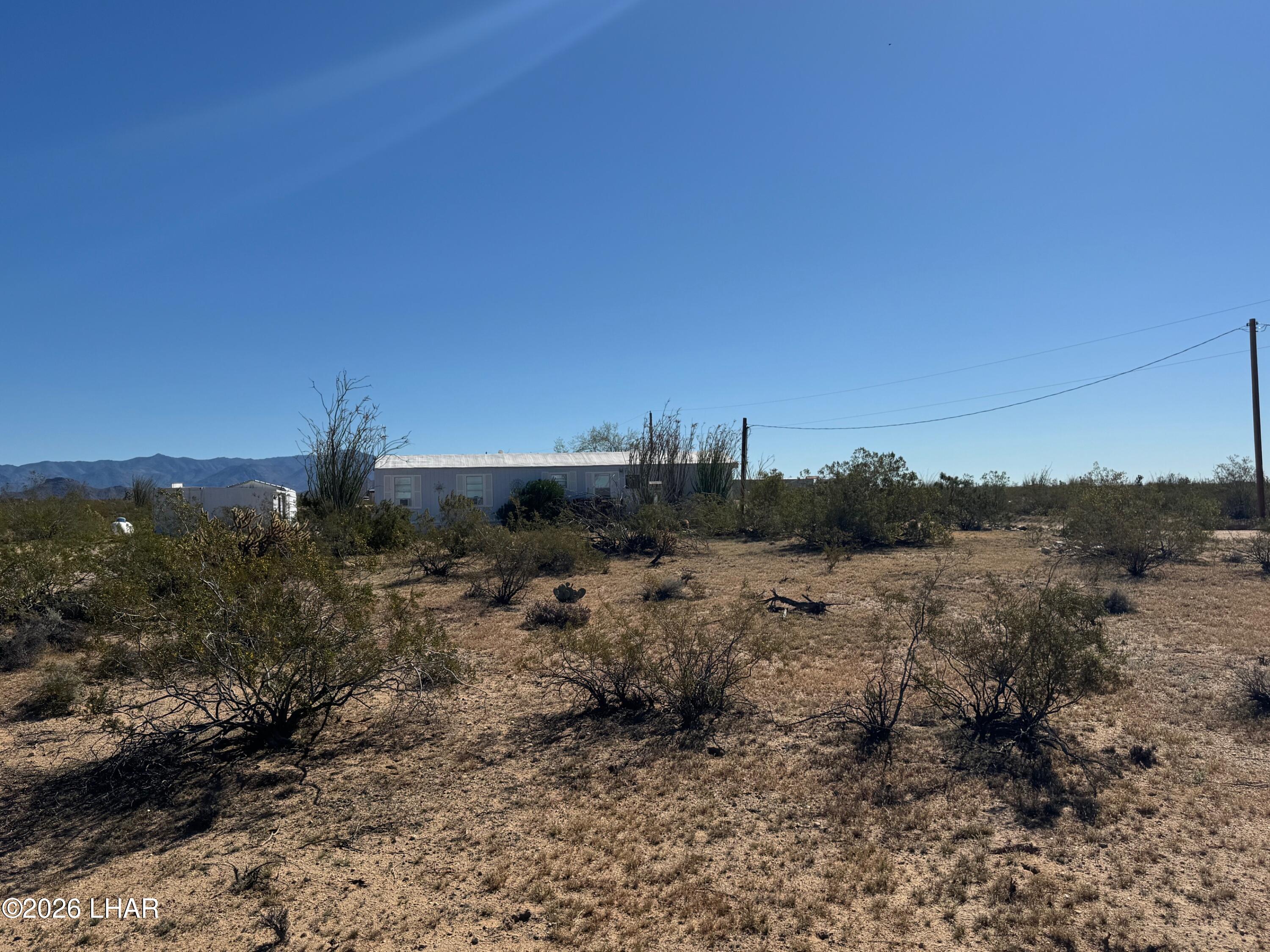 15454 Mohave Road Yucca, AZ 86438 - Photo 46 of 47 a view of a dry field with trees in the background