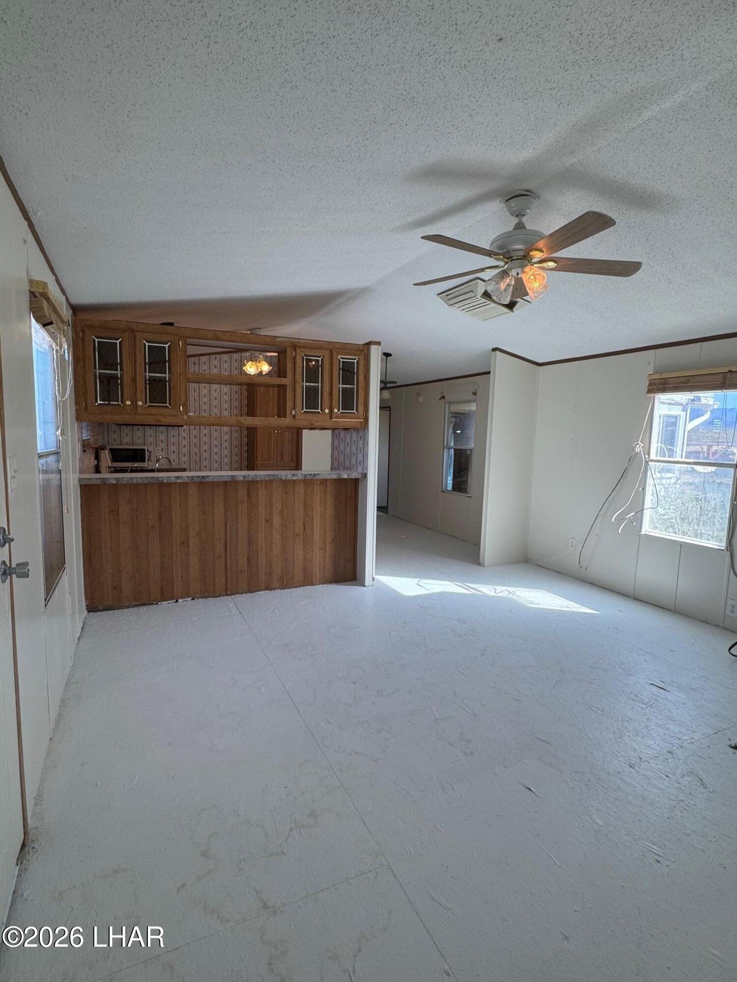 15454 Mohave Road Yucca, AZ 86438 - Photo 8 of 47 an empty room with chandelier fan and windows