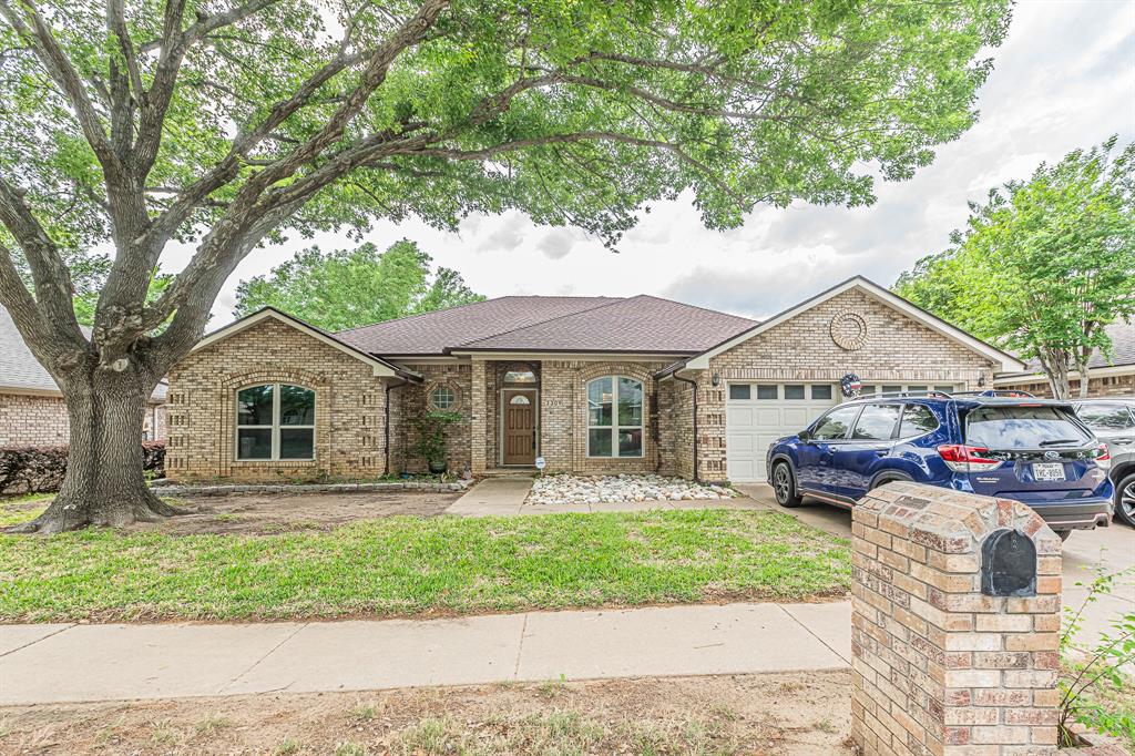3309 Timber View Circle Bedford, TX 76021 - Photo 1 of 38 a front view of a house with a garden and trees