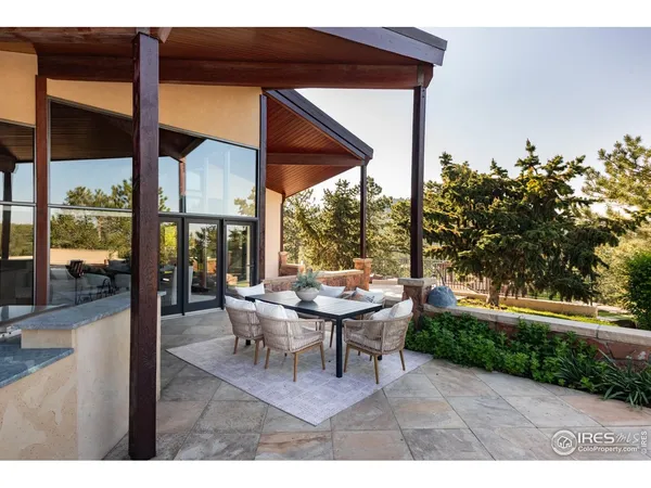 a view of a patio with table and chairs under an umbrella
