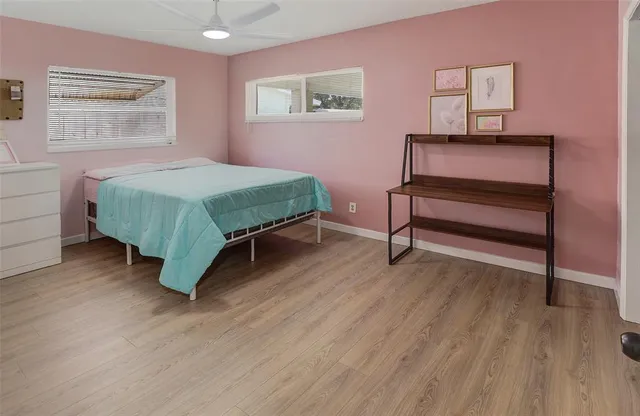 a bedroom with a bed wooden floor and window