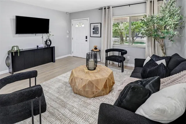 a living room with furniture a flat screen tv and a large window