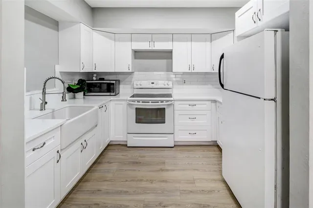 a kitchen with white cabinets and white appliances