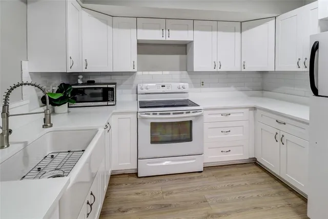 a kitchen with cabinets appliances and a sink