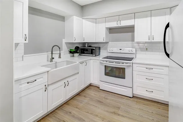 a kitchen with white cabinets stainless steel appliances and sink