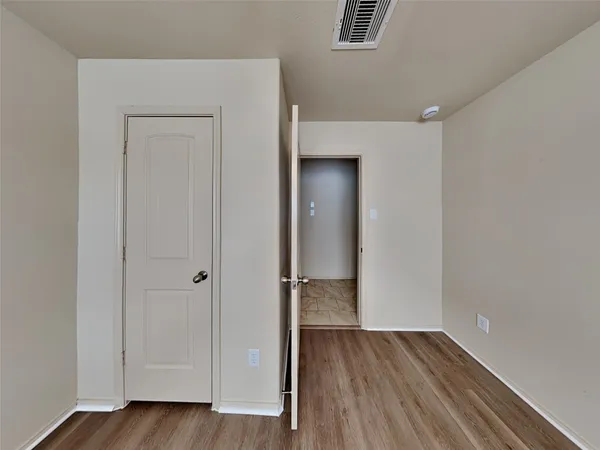 an empty room with wooden floor and closet