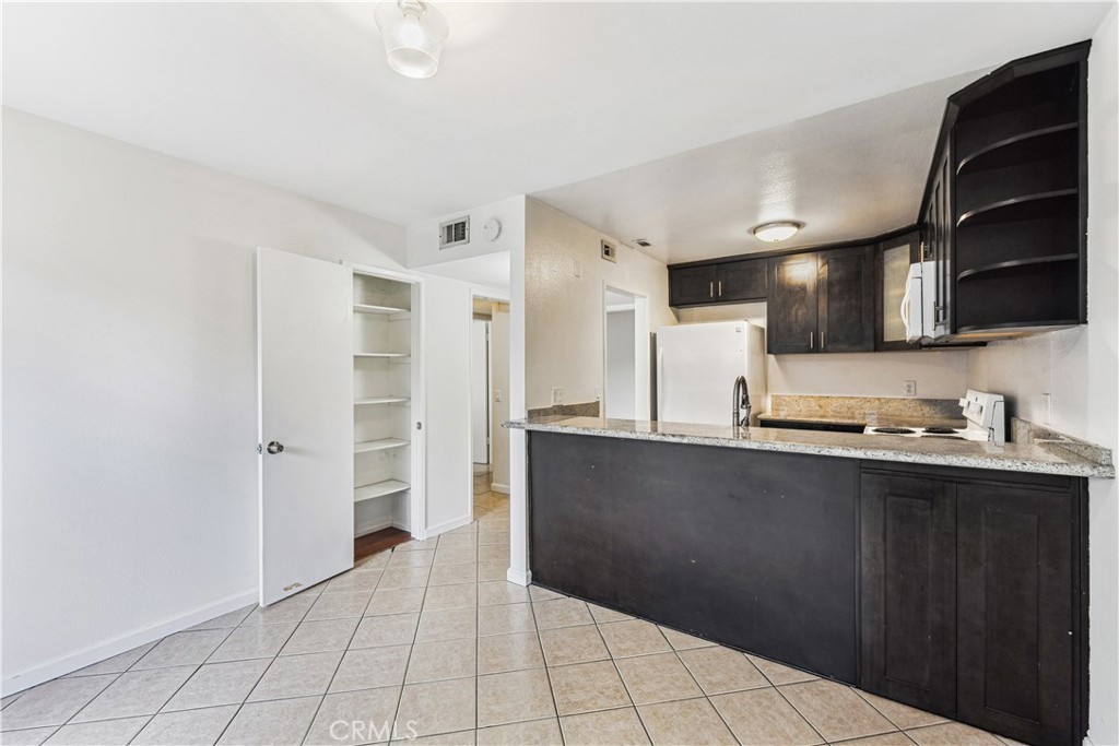 999 West Pine Street, Unit D Upland, CA 91786 - Photo 13 of 16 a kitchen with stainless steel appliances a refrigerator and a sink