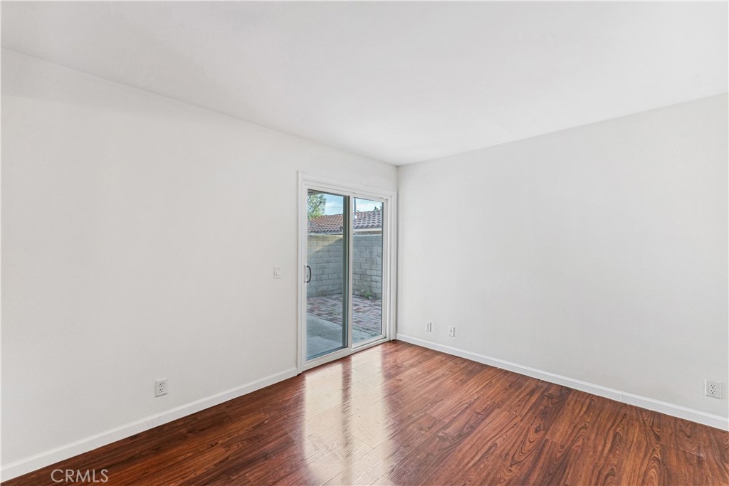 999 West Pine Street, Unit D Upland, CA 91786 - Photo 3 of 16 an empty room with wooden floor and windows