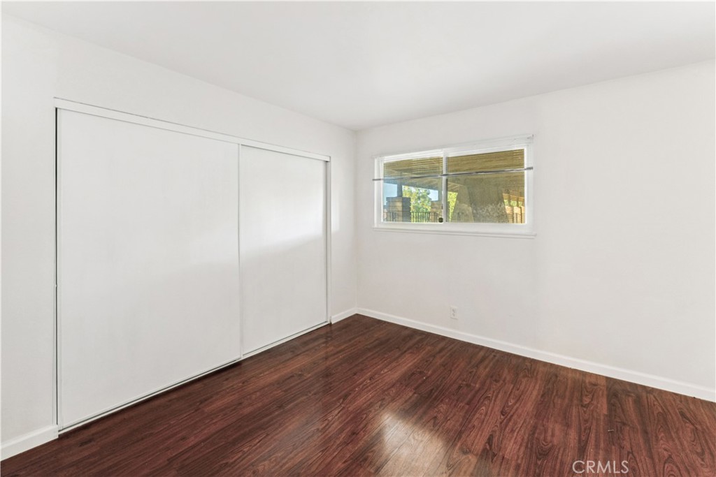 999 West Pine Street, Unit D Upland, CA 91786 - Photo 8 of 16 an empty room with wooden floor and windows