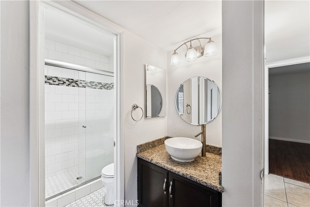 999 West Pine Street, Unit D Upland, CA 91786 - Photo 10 of 16 a bathroom with a granite countertop sink toilet and shower