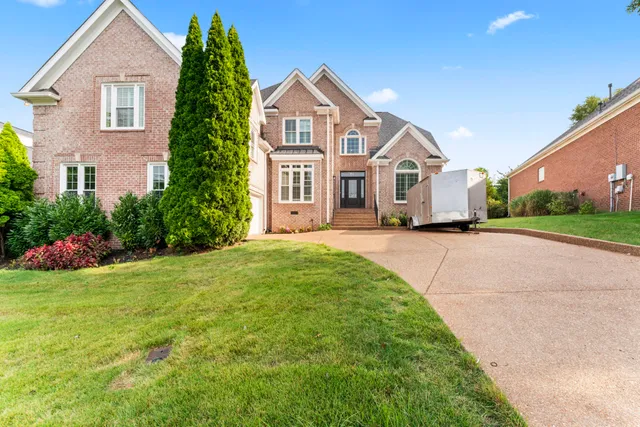 a front view of a house with a garden and yard