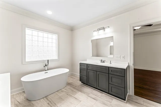 a spacious bathroom with a tub sink and mirror