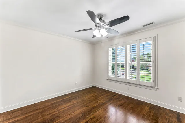 a view of a big room with wooden floor and chandelier fan in a room