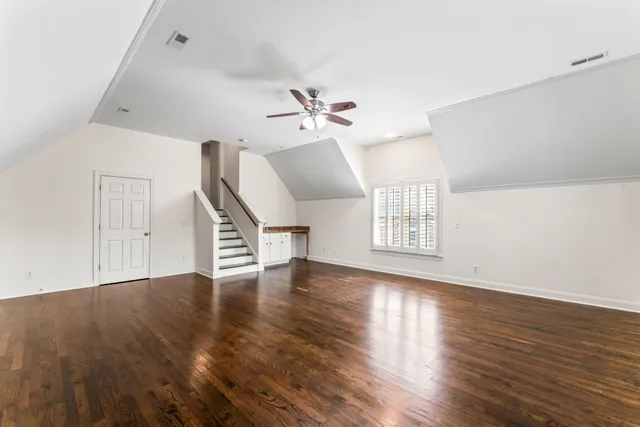 a view of a room with wooden floor and ceiling fan