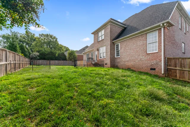 a view of a white house next to a yard